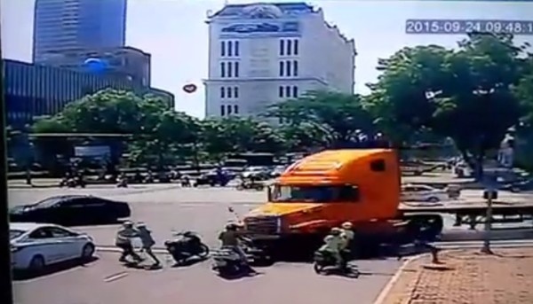 Khoảng khắc người đi đường vứt xe chạy lên vỉa hè tránh container thoát chết trong gang tấc. Ảnh: Cắt từ clip.