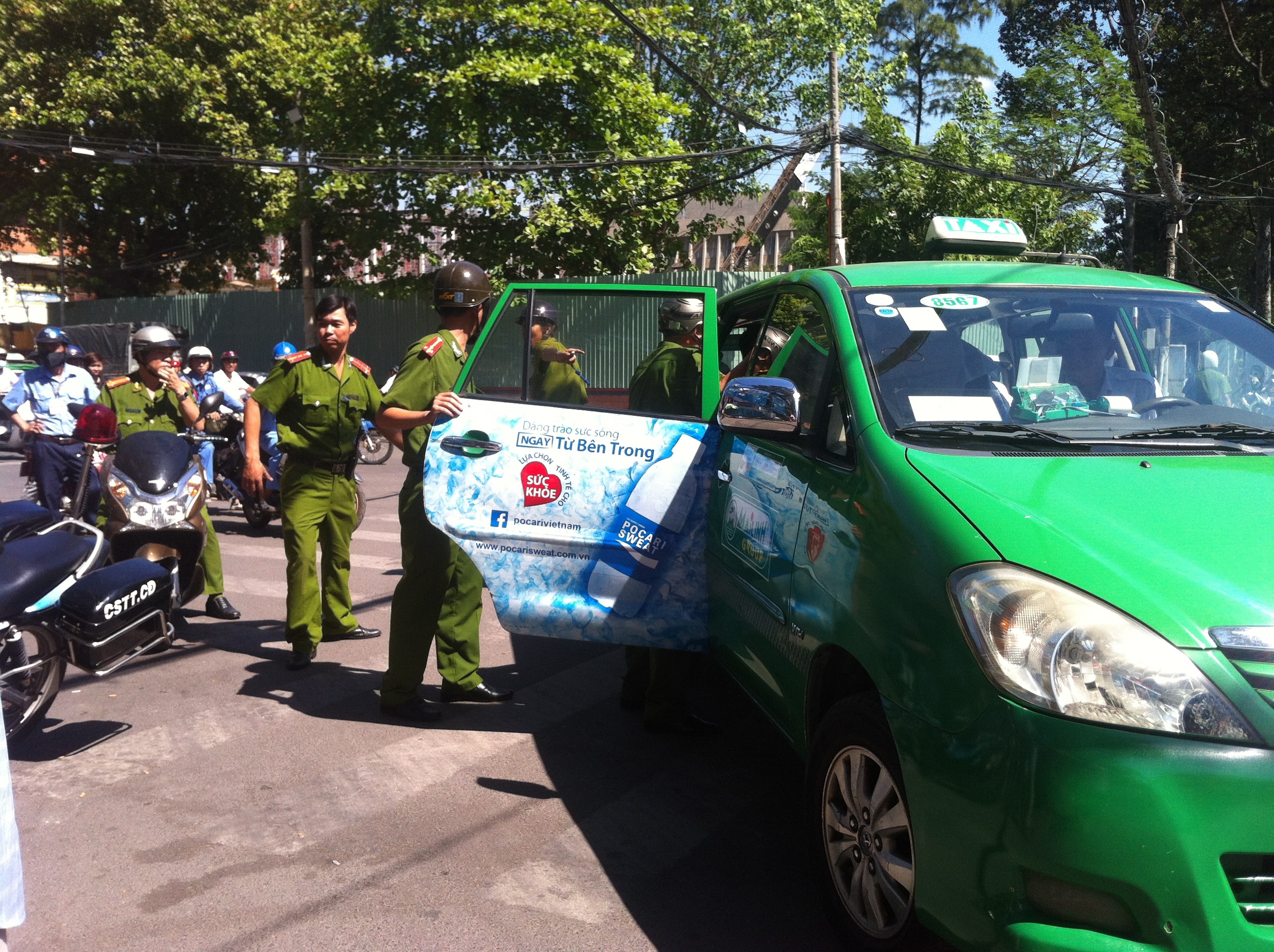 Cảnh sát đưa 2 nghi can lên xe taxi chở về công an phường lấy lời khai. Ảnh: Khánh Trung.