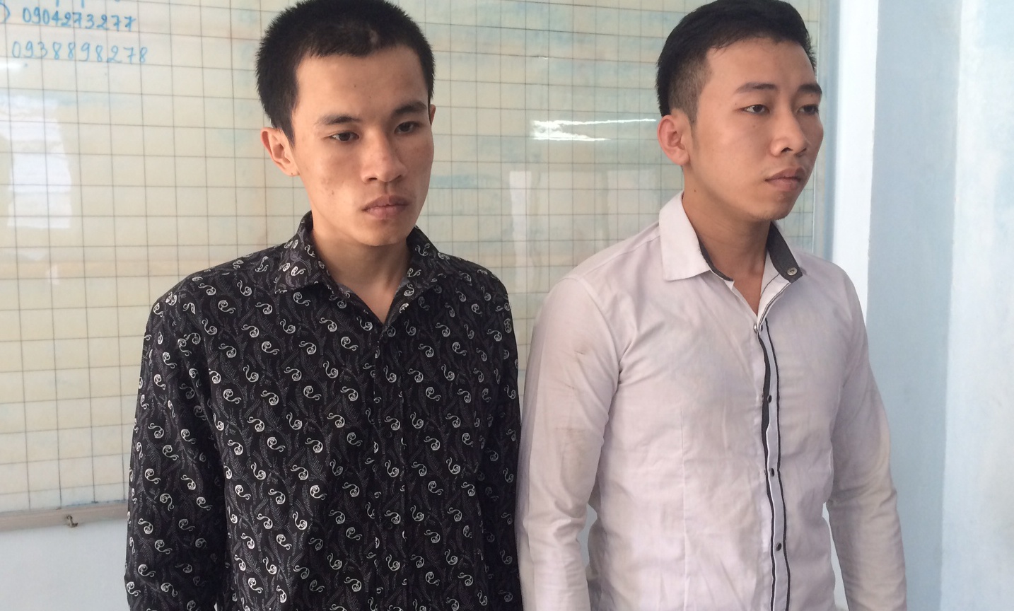 Thắng (áo đen) và Sơn đang bị công an bắt giữ. Ảnh: Khánh Trung.