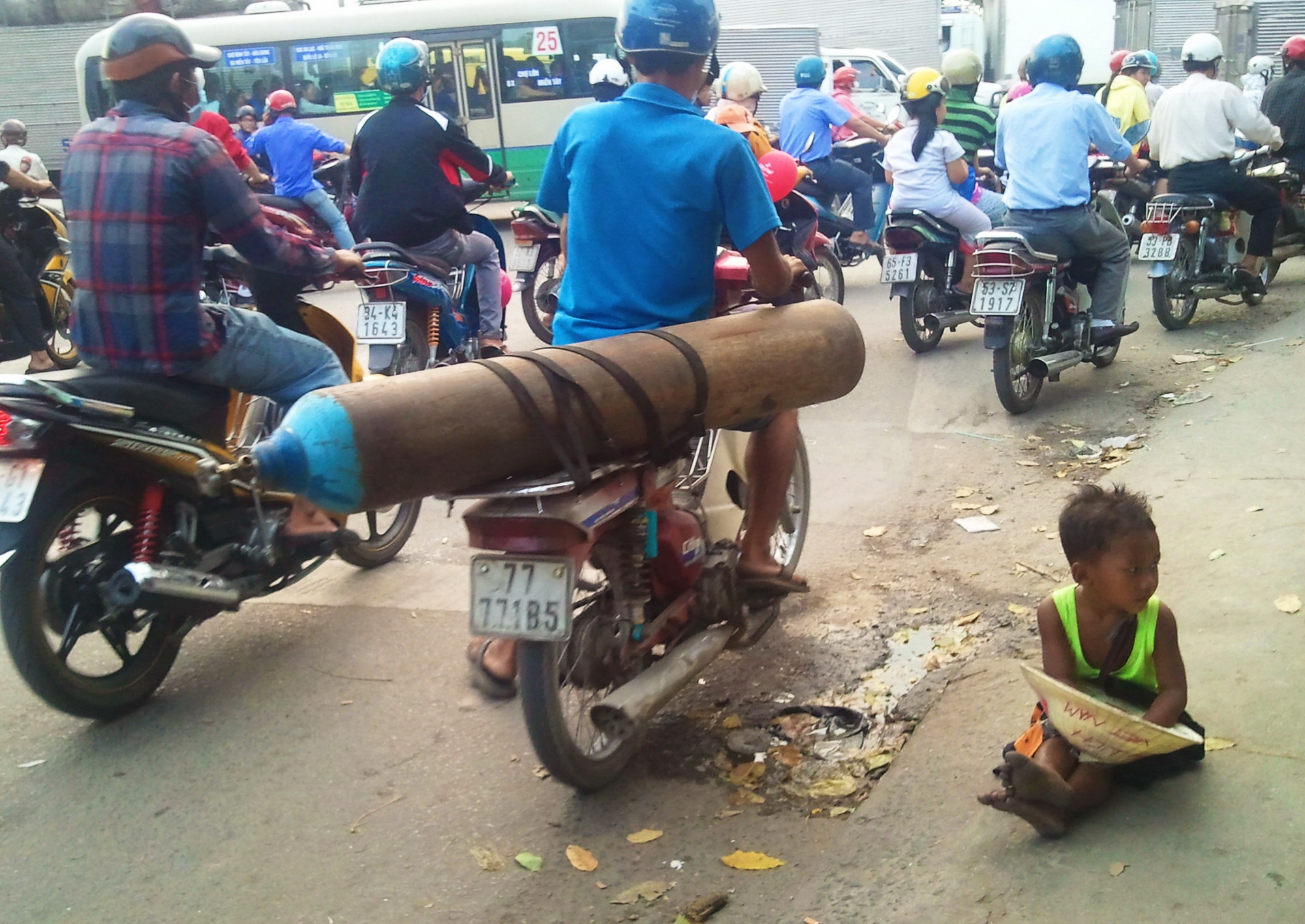 'Me min' ngoi hong mat, tre dung giua nang Sai Gon xin tien hinh anh