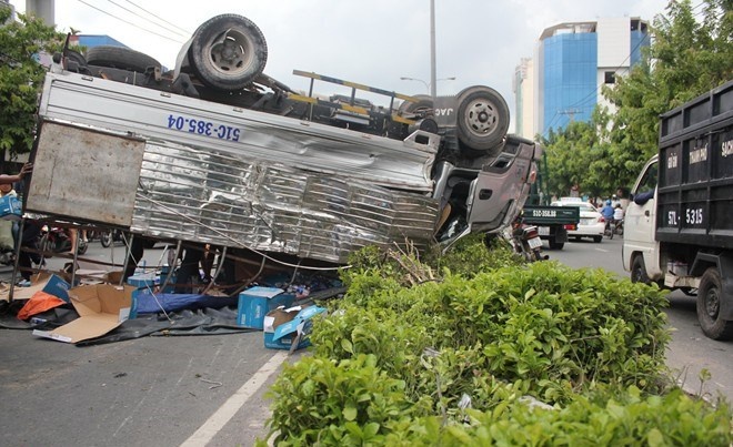 Xe tai lat giua duong, nguoi dan gom nuoc khoang giup tai xe hinh anh