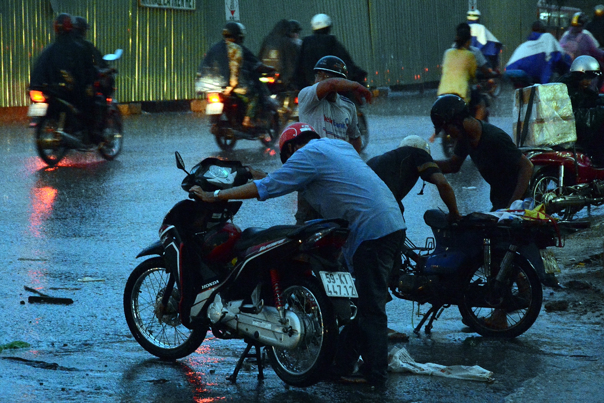 Sau khi mưa ngớt, nhiều người phải dựng xe trên đường phố để sửa do chết máy.Ảnh: Minh Thanh.