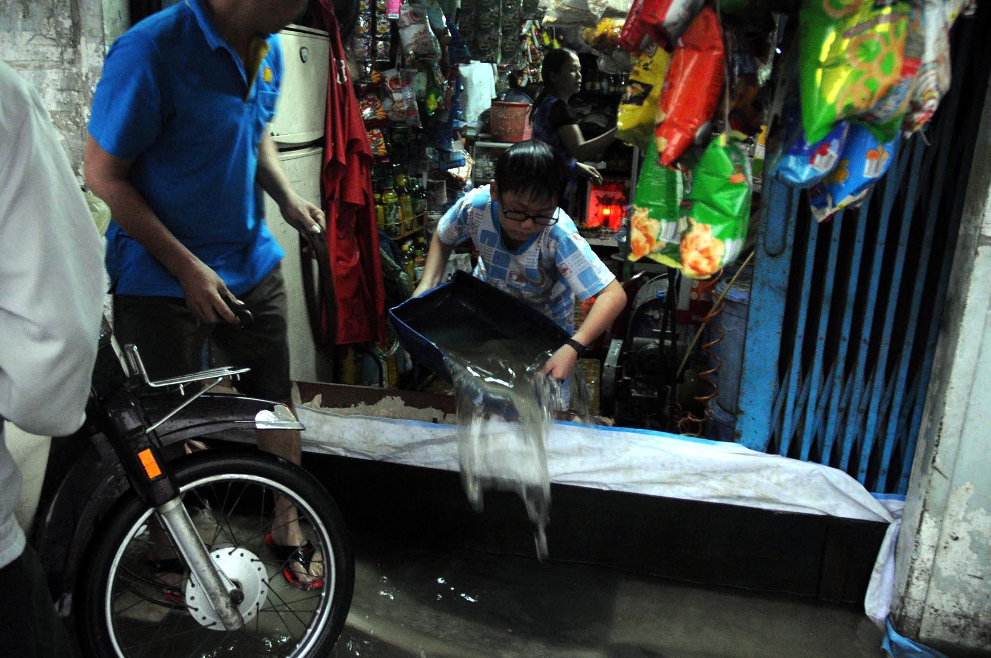 Đã quá quen với cảnh ngập nước, người dân chuẩn bị thau chậu để tát nước ra khỏi nhà.