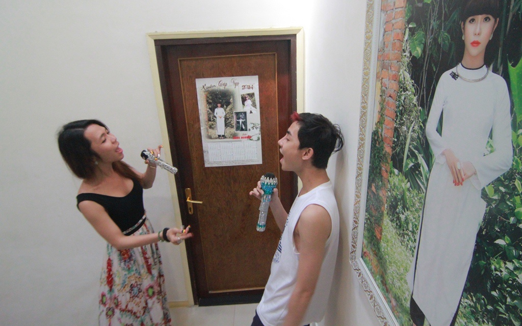 Cô hướng dẫn thành viên trong nhóm nhạc tập hát.