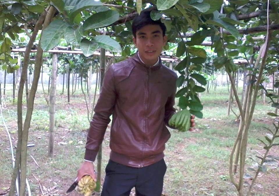 Phạm Văn Xoa bên vườn phật thủ của mình.