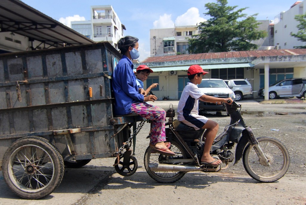 Cau be 14 tuoi lai xe cho em trai va me di gom rac hinh anh