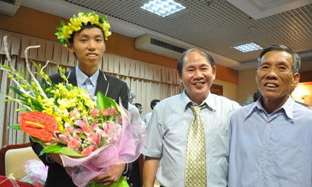 Hiệu trưởng Trường THPT chuyên Khoa học tự nhiên Nguyễn Vũ Lương (giữa) chia sẻ niềm vui cùng Hoàn và ông ngoại em.