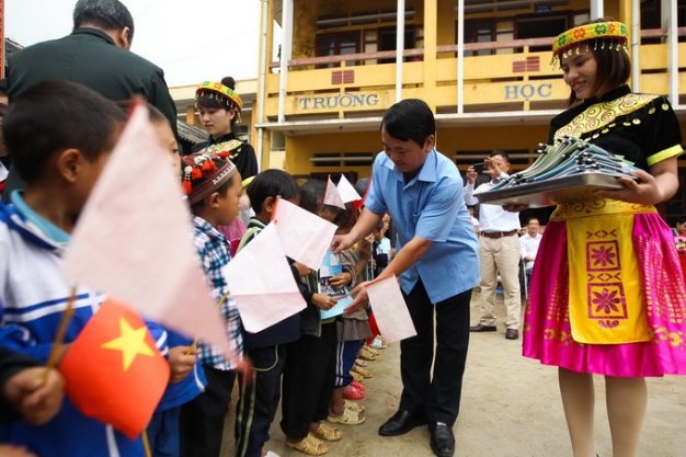 Bí thư huyện Sa Pa Hầu A Lềnh tặng vở cho các học sinh lớp 1.