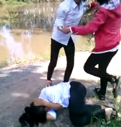 Mặc dù được bạn ngăn cản nhưng Dung vẫn cố tình đánh bạn. Ảnh: Cắt từ clip.