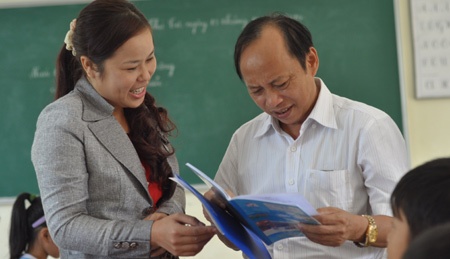 Ông Trần Thế Sơn kiểm tra vở học sinh Trường tiểu học Làng Sen (huyện Nam Đàn, tỉnh Nghệ An).