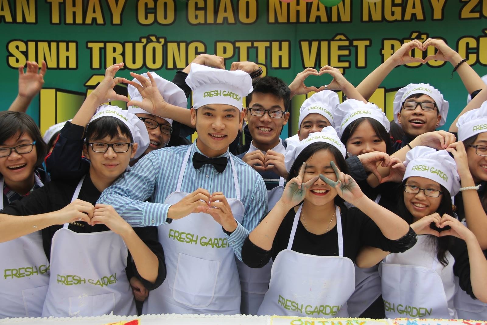 Trong ngày này, tại trường THPT Việt Đức, chiếc bánh kem hình cuốn sách, kích thước 1,2 m x 2,4 m, nặng 100 kg được học sinh tự tay làm để tặng thầy cô. Ca sĩ Duy Khoa cũng trở về trường cùng các em khóa dưới làm bánh. Ảnh: FBNV.