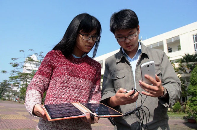 Hai bạn Đoàn Trần Viên và Nguyễn Thủy Tiên thử nghiệm sản phẩm sạc pin điện thoại bằng năng lượng mặt trời.