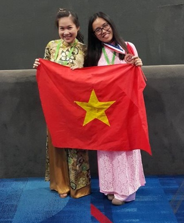 Cô Khánh Vân và học trò của mình bên chiếc huy chương Đồng