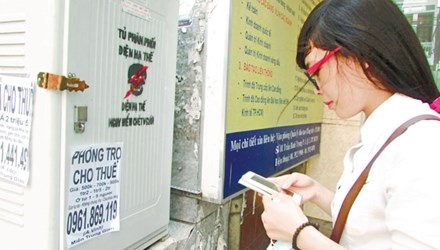 Sinh viên Nguyễn Thị Mỹ Hoa đang liên hệ với thông tin cho thuê nhà trọ được dán trên tủ phân phối điện hạ thế.