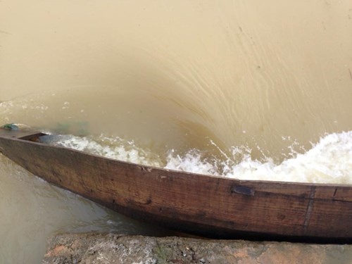 Con thuyền bị dòng lũ cuốn.