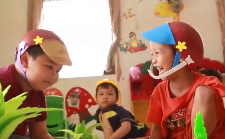 Gap lai cau be luom ve chai xep dep cho co giao o cong vien hinh anh