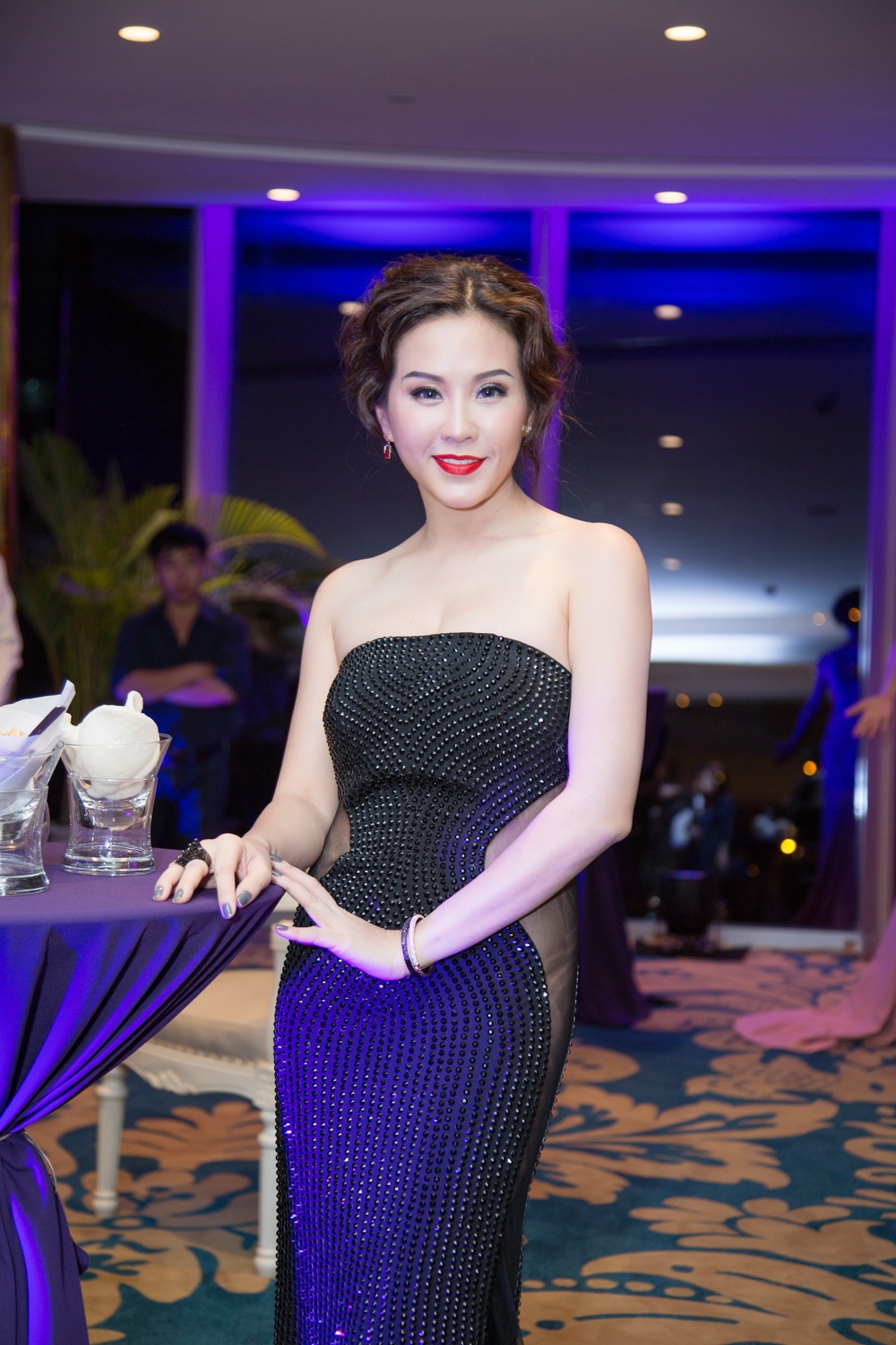 Trang phục dạ hội dáng quây khoe lợi thế vai trần gợi cảm, chất vải xuyên thấu táo bạo hai bên hông váy tạo sức quyến rũ cho người mặc. Bộ cánh giúp nữ doanh nhân thu hút sự chú ý ở đêm tiệc. Đi kèm trang phục đẳng cấp là mái tóc và tông trang điểm cổ điển và không kém phần quyến rũ. Phụ kiện nhẫn cũng rất ăn ý. 