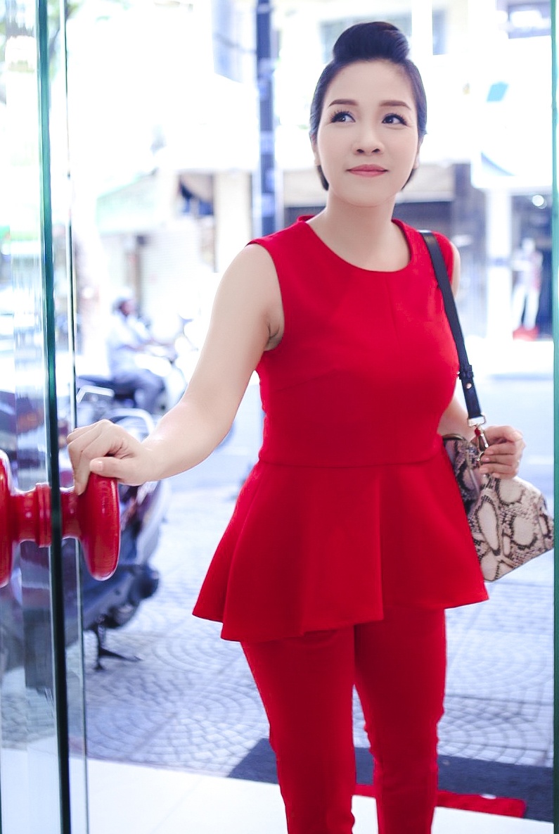 Chiều 5/10, ca sĩ Mỹ Linh đến thăm quan và thử trang phục tại showroom của NTK Đỗ Mạnh Cường tại TP.HCM. Cô diện bộ trang phục tông màu đỏ nổi bật, có đường nét tối giản. Bộ cánh dáng áo peplum rộng và quần ống đứng giúp giọng ca Tóc ngắn trông thon gọn hơn.