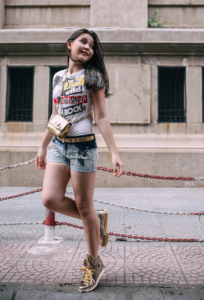 Trong ảnh là set đồ quần, áo, giày, túi Young Versace mix ăn ý. Áo thun in chữ trẻ trung kết hợp cùng giày thể thao giúp cô bé thêm phần năng động khi xuống phố. 