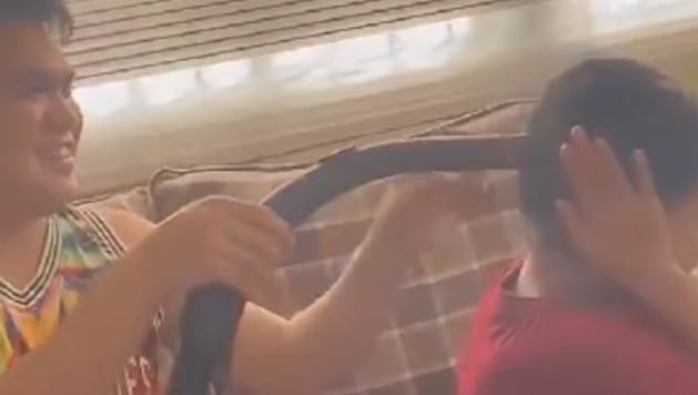 Anh trai buoc toc cho em bang may hut bui hinh anh