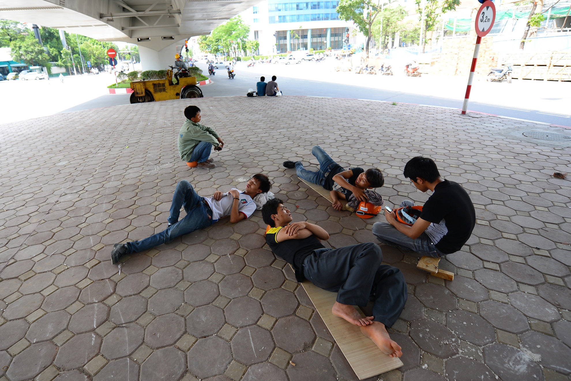 Vỉa hè dưới chân cầu vượt, đường trên cao được người lao động tận dụng làm nơi ngả lưng nghỉ trưa và tránh nắngVỉa hè dưới chân cầu vượt, đường trên cao được người lao động tận dụng làm nơi ngả lưng nghỉ trưa và tránh nắng. Người đi xe máy dừng tại nơi có bóng cây chờ đèn tín hiệu.