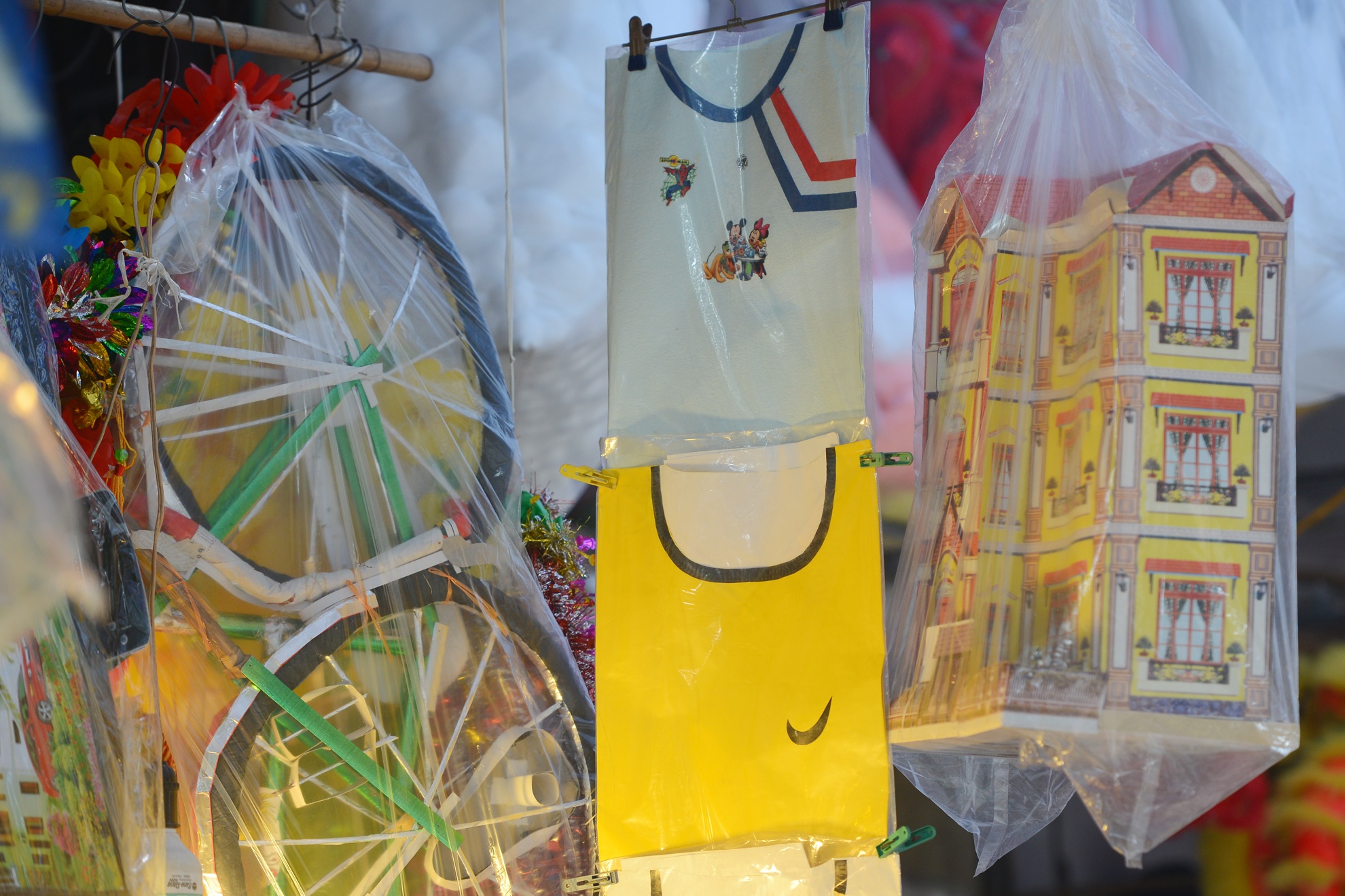 Nhiều sản phẩm mới lạ mắt bên cạnh những sản phẩm cũ như biệt thự, xe cộ cũng được bày bán dọc phố Hàng Mã trong dịp rằm tháng 7 năm nay như áo thể thao Nike, Adidas cho mùa World Cup vừa qua.