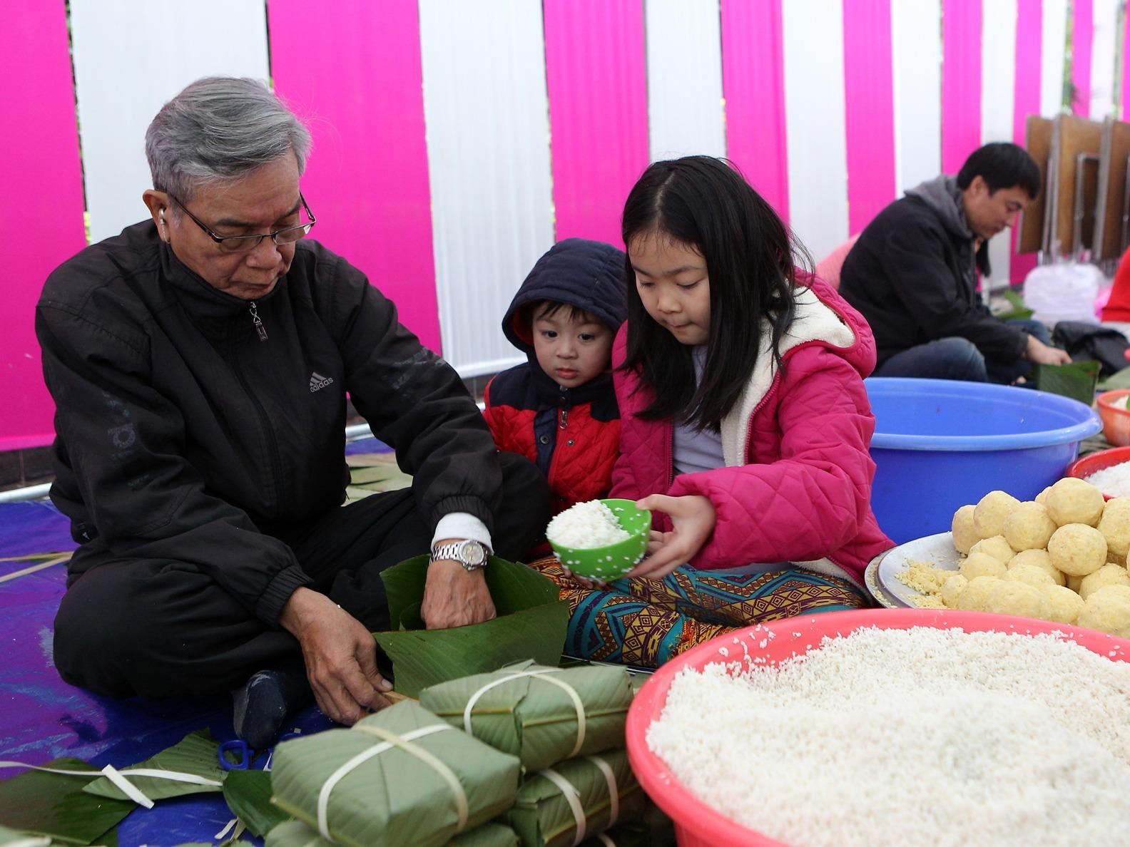 Hang chuc gia dinh quay quan, cung nhau goi banh chung don Tet hinh anh