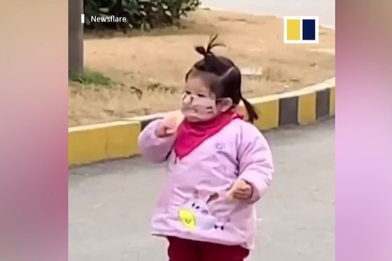 Be gai co an banh quy du dang deo khau trang tranh virus corona hinh anh