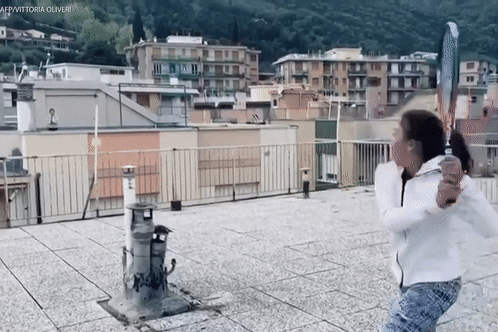 Hai co be choi tennis tu san thuong cua hai toa nha doi dien nhau hinh anh