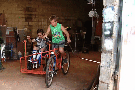 Cau be 11 tuoi che xe dap dac biet cho em trai bi liet hinh anh