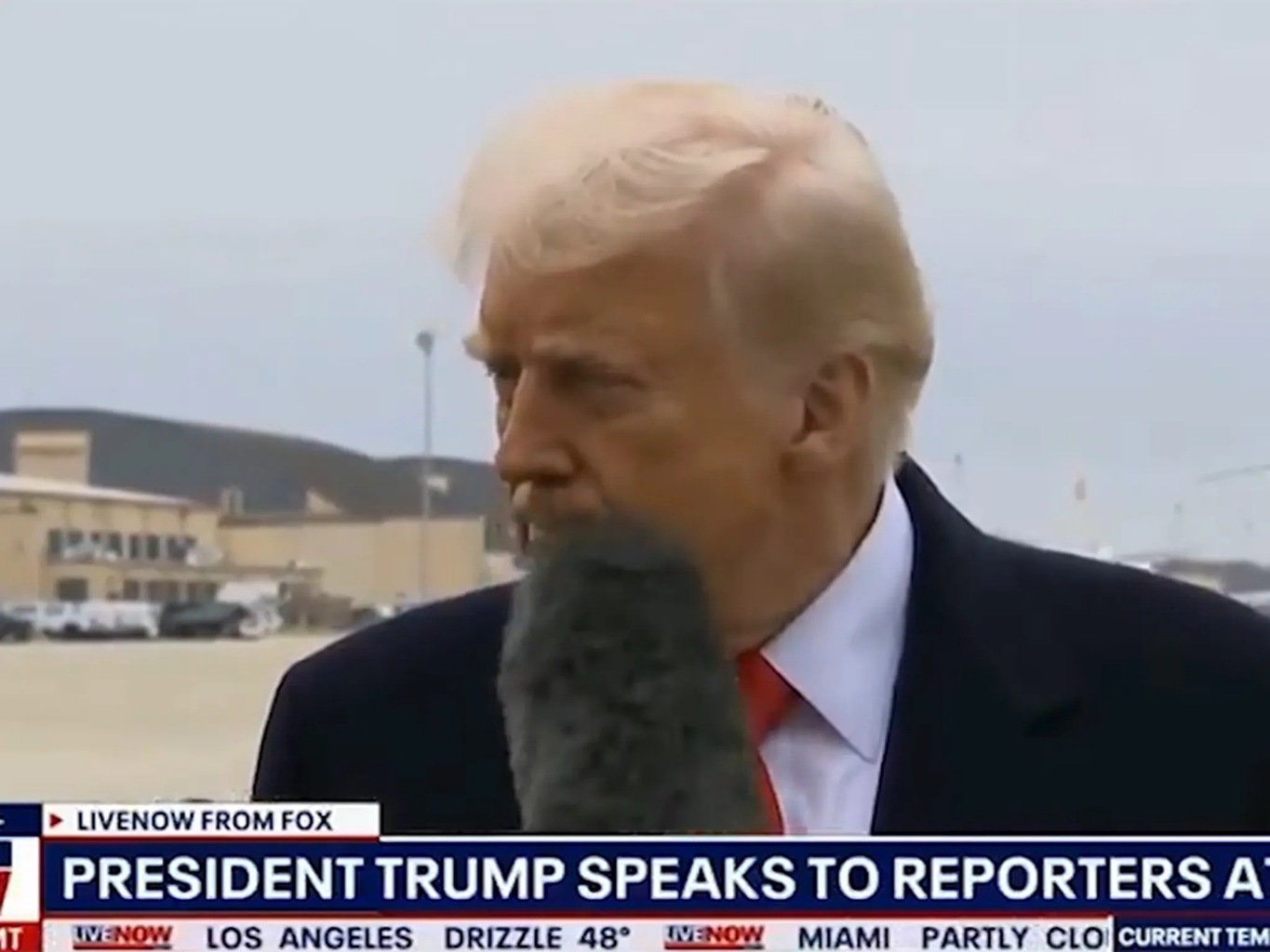 Ong Trump bi micro cua phong vien quet vao mat hinh anh