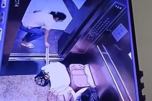 Nguoi phu nu bong con dung thanh sat chan cua thang may gay tranh cai hinh anh