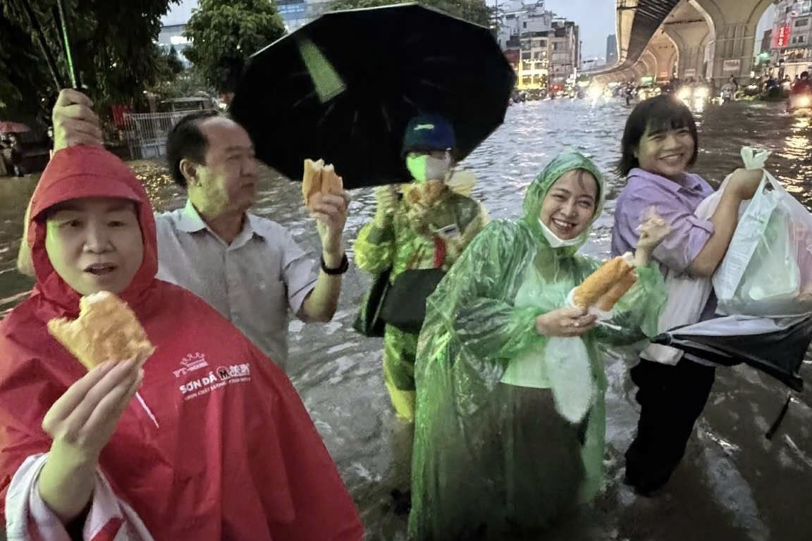 Chia nhau mau banh mi, cuoc xe trong tran ngap nang o Ha Noi hinh anh