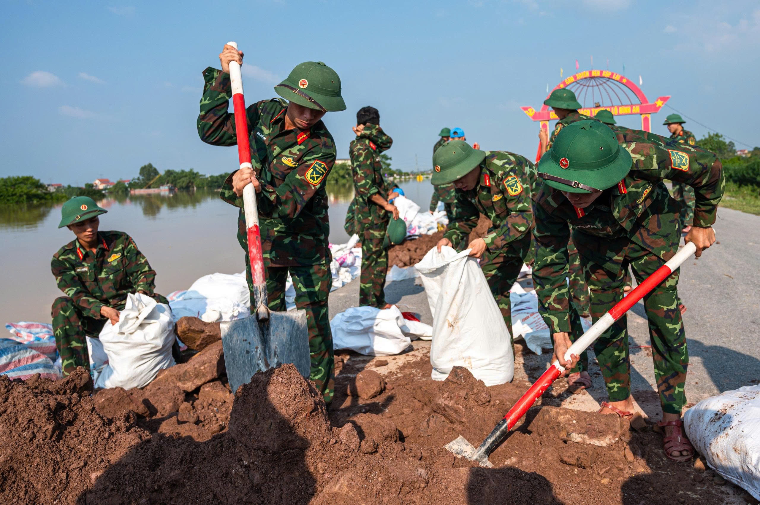 Nguoi dan, bo doi dap de ngan nuoc lu song Cau hinh anh