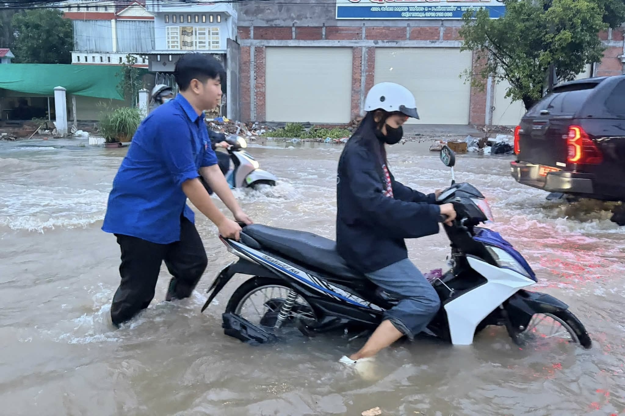 Triều cường dâng cao, người đi xe ngã nhào xuống dòng nước đục ngầu