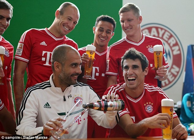 Dig in: Manager Pep Guardiola (front left) and Spaniard Javi Martinez (bottom right) enjoy a Paulaner