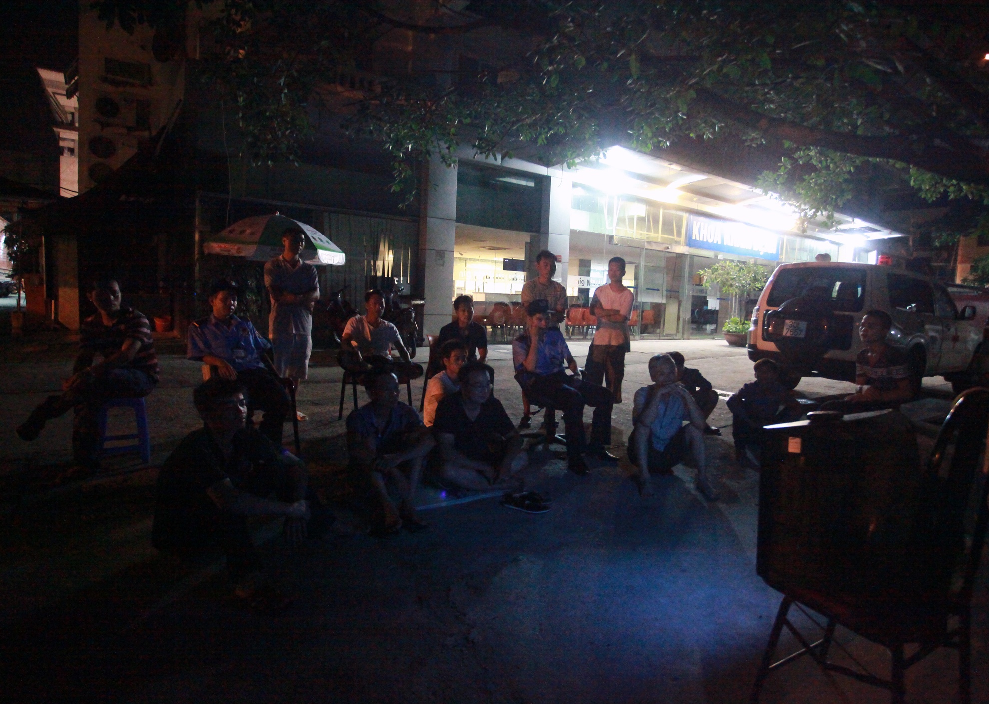 Bảo vệ khi hết giờ phải mở cổng để xe ra vào, cánh lái xe taxi cùng người nhà bệnh nhân tại bệnh viện lão khoa trung ương tập trung qua chiếc màn hình nhỏ đặt ngoài sân viện.