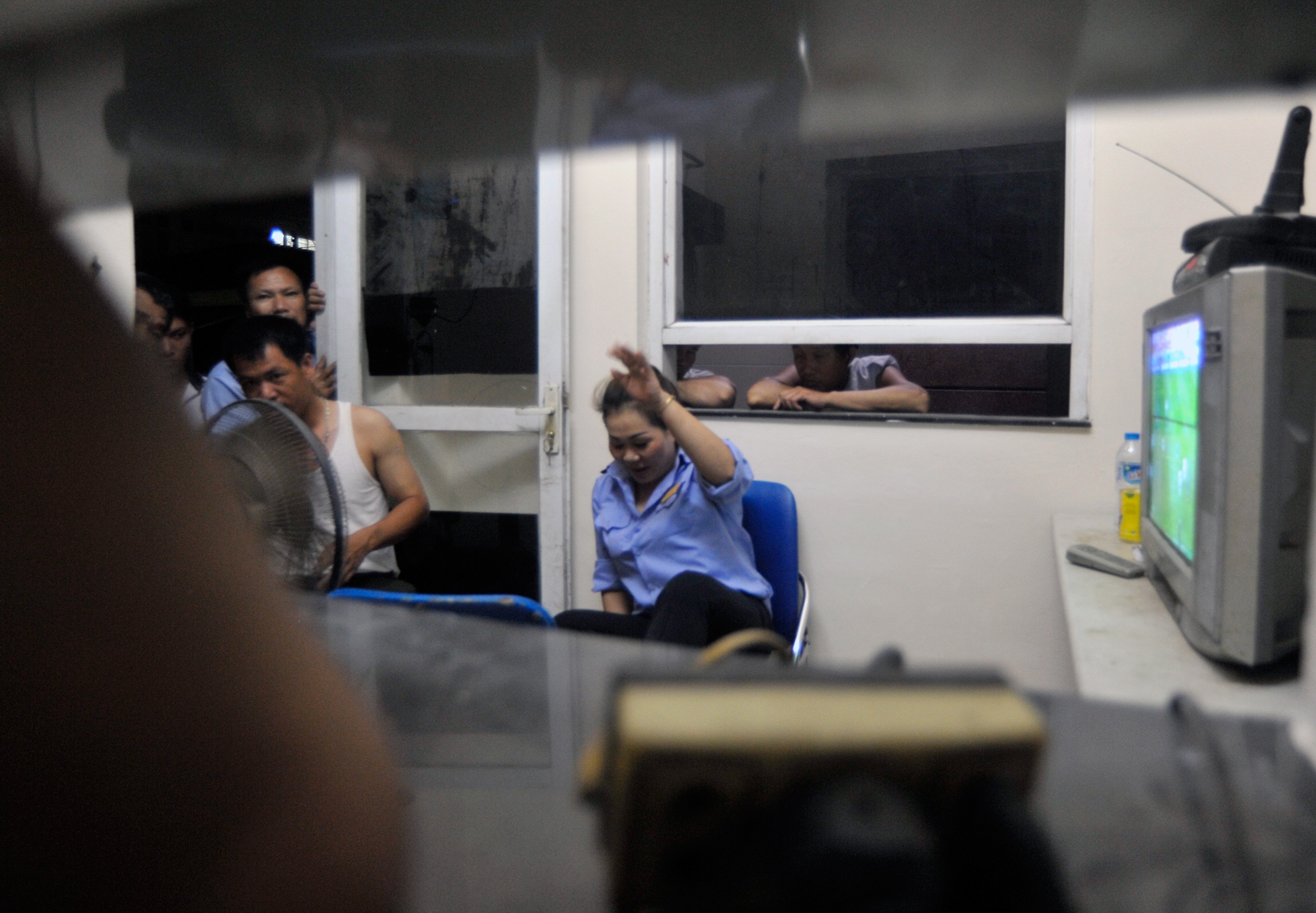 Tại cổng chính bệnh viện Bạch Mai, các anh xe ôm,  taxi ghé mắt nhìn qua ô thoáng nhỏ trên cửa kính và cửa ra vào của phòng bảo vệ để xem trận đấu khi chưa có khách.