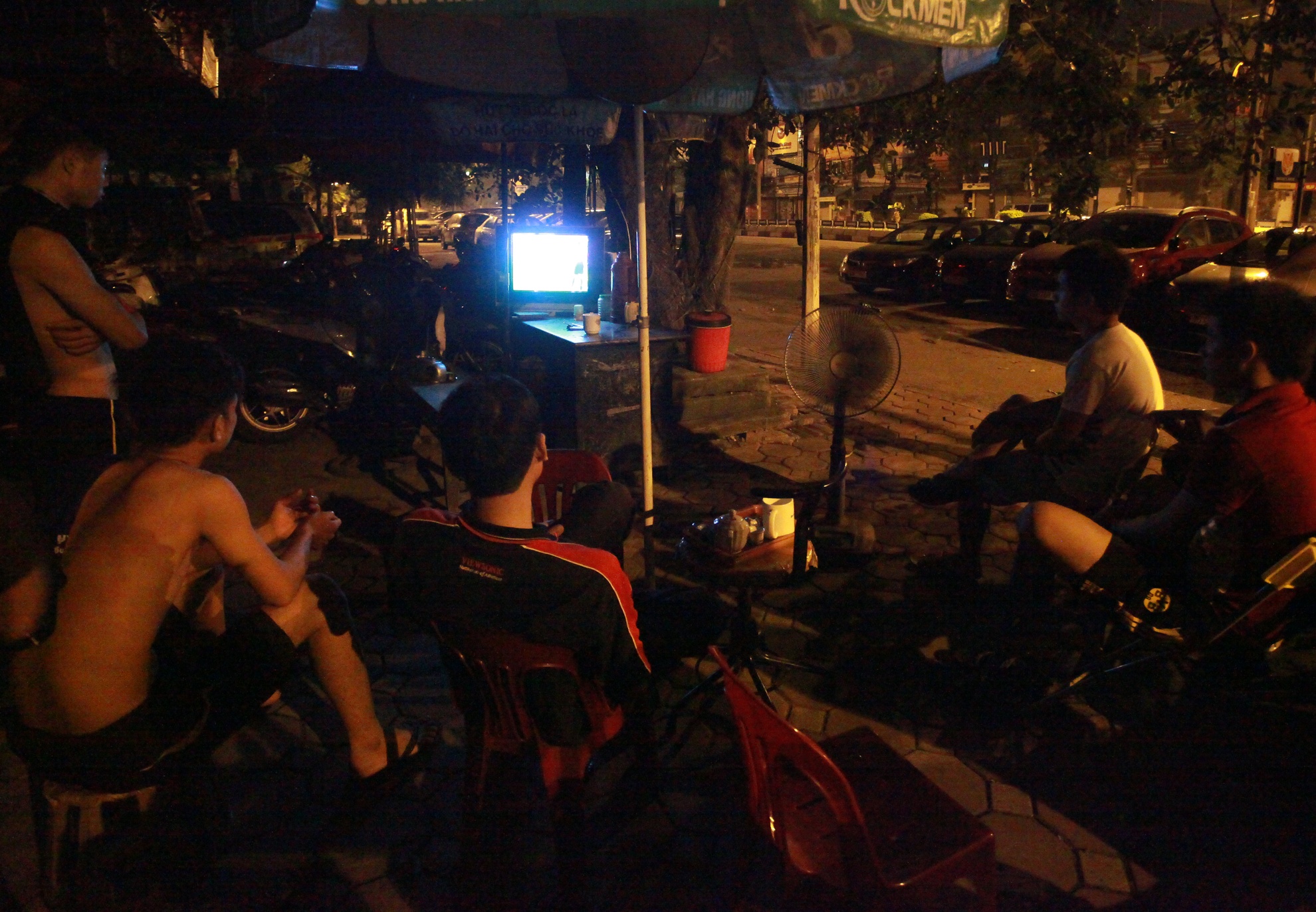 Điểm trông xe trên phố Trần Khát Chân, thời tiết oi nóng trước cơn mưa nhưng không ngăn được nhiệt huyết của nhiều thanh niên ngồi xem.