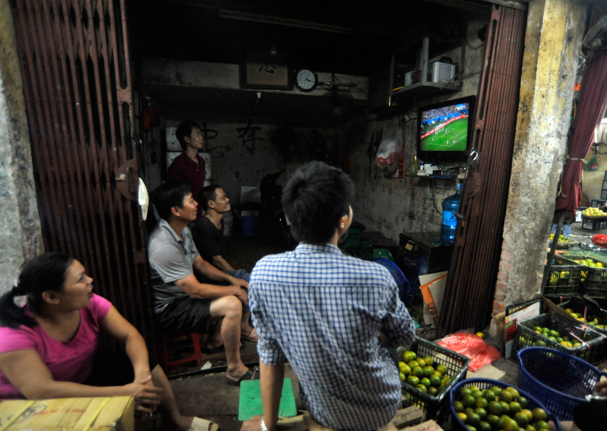 Nhộn nhịp nhất vẫn là chợ hoa quả Long Biên, nhiều bà con tiểu thương trong lúc chờ các đại lí đến lấy hàng hoặc xe tải về hàng thì lại dán mắt lên chiếc màn hình trong sạp hàng.