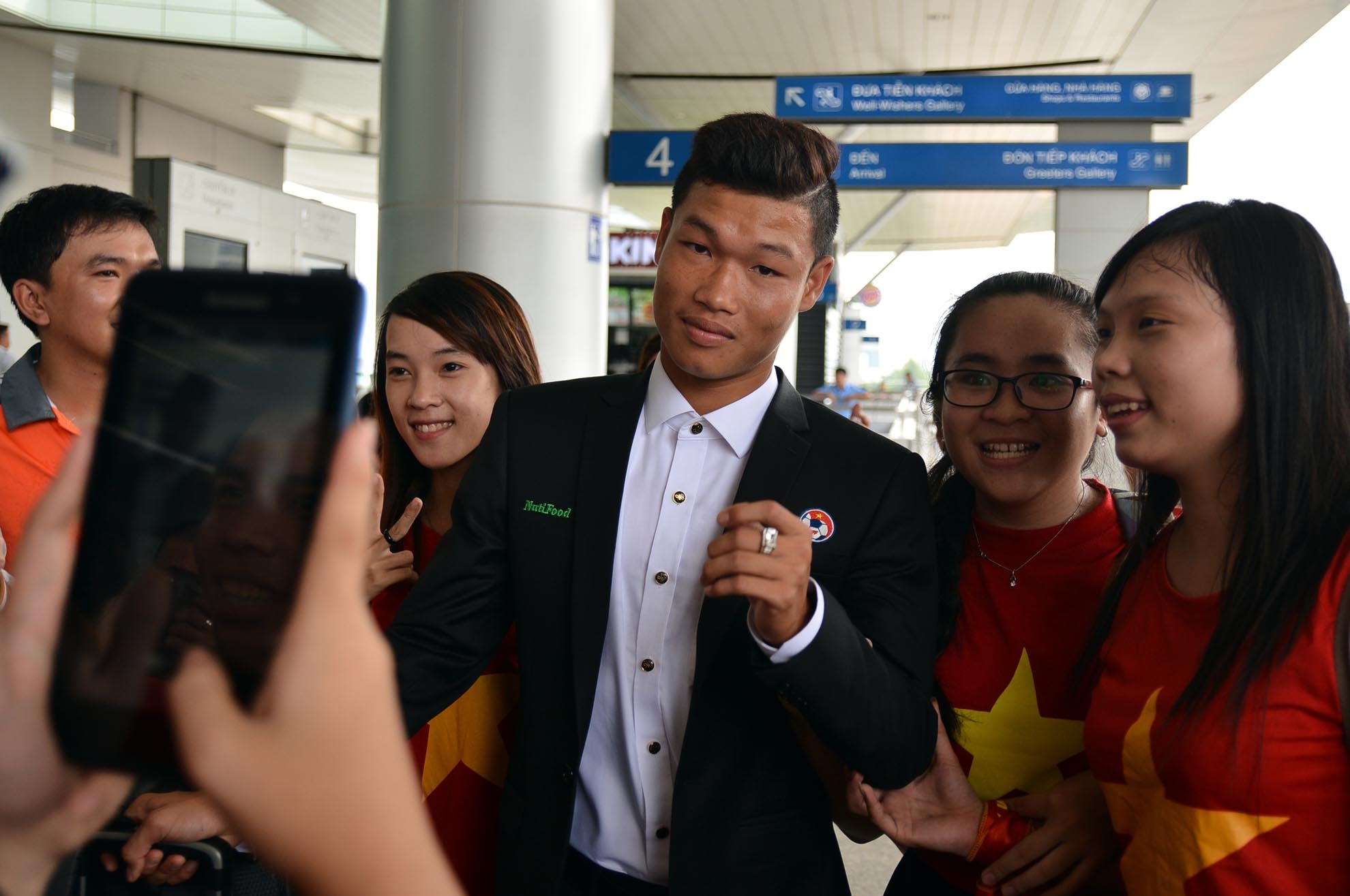 Trung vệ Trần Hữu Đông Triều trong vòng vây của người hâm mộ.