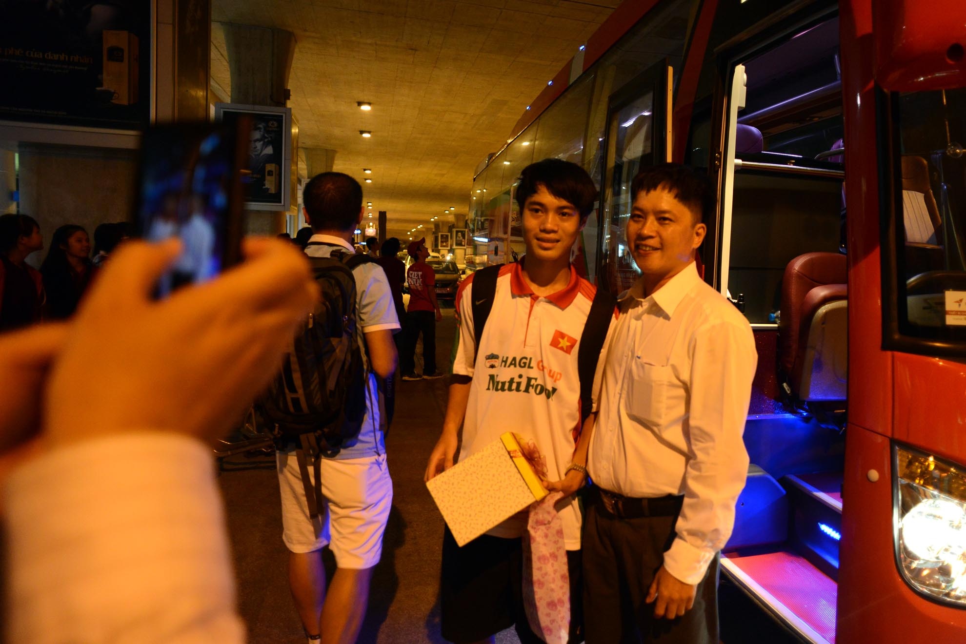 CĐV tranh thủ chụp hình với các cầu thủ. Trong chuyến bay này, chỉ có các cầu thủ của Học viện HAGL trở về.