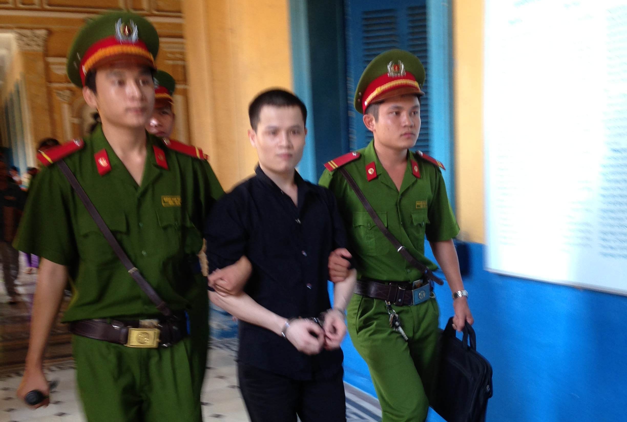 Hung thủ bị dẫn giải sau phiên tòa.