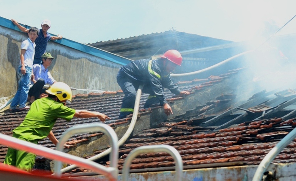 Canh sat PCCC treo len mai nha de khong che ngon lua hinh anh