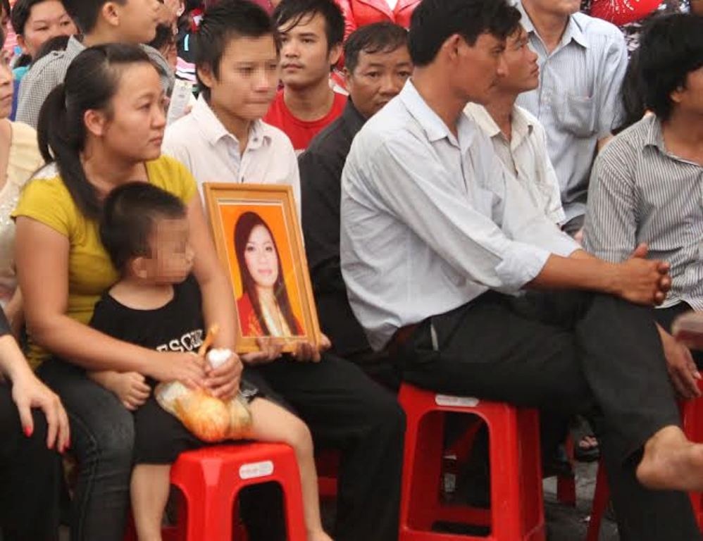 Đứa trẻ ngây thơ nhìn di ảnh mẹ.