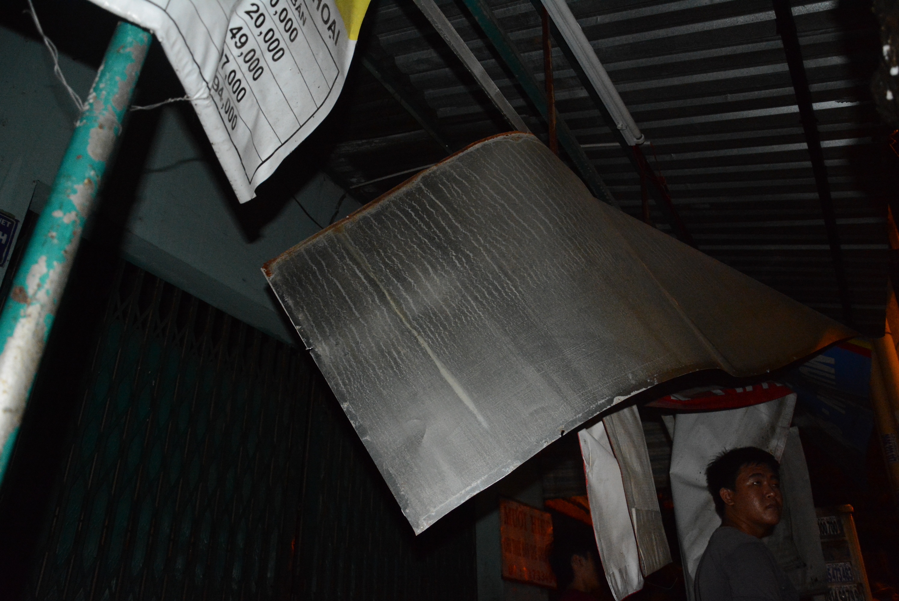 Mái che trước hiên của một căn nhà đối diện bị lực của vụ nổ đẩy sắp bay.