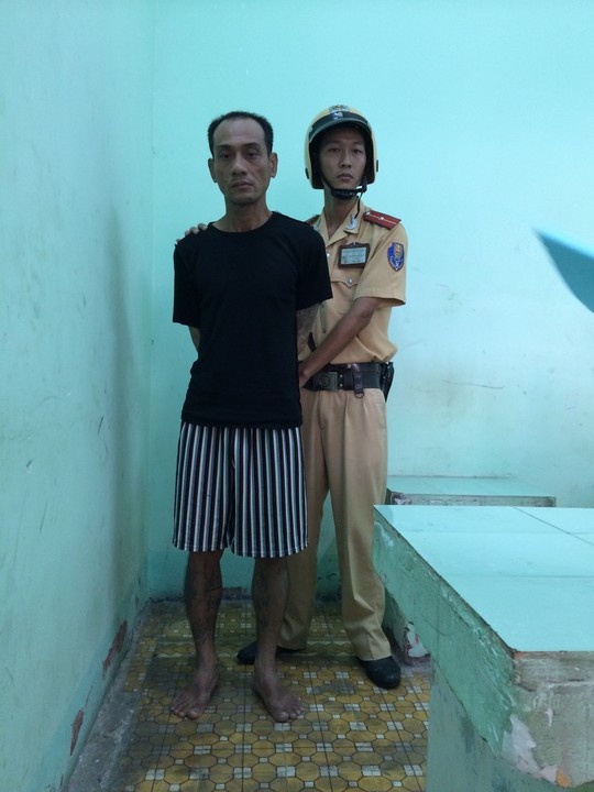 Hứa Thanh Tùng (áo đen) bị CSGT áp giải đến công an phường.