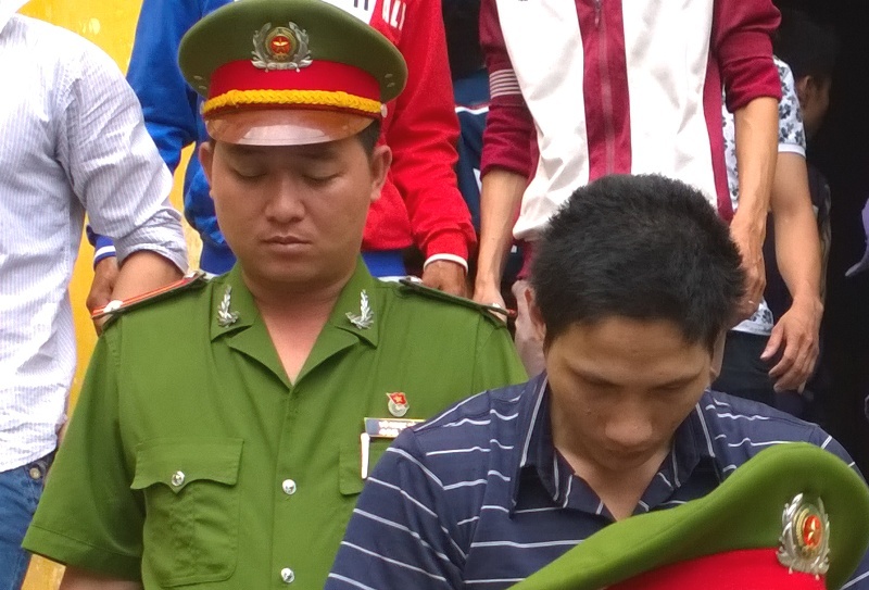Hưởng xấu hổ cúi mặt khi bị dẫn giải sau phiên tòa.