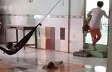 Sau đó người phụ nữ này kẹp cháu bé đầu chúc ngược, vừa đi vừa đánh.