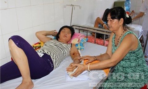 Mẹ chị N. chăm sóc cho nạn nhân tại bệnh viện.